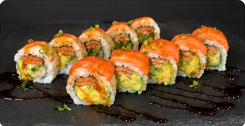 Kitsune roll topped with salmon on a slate plate